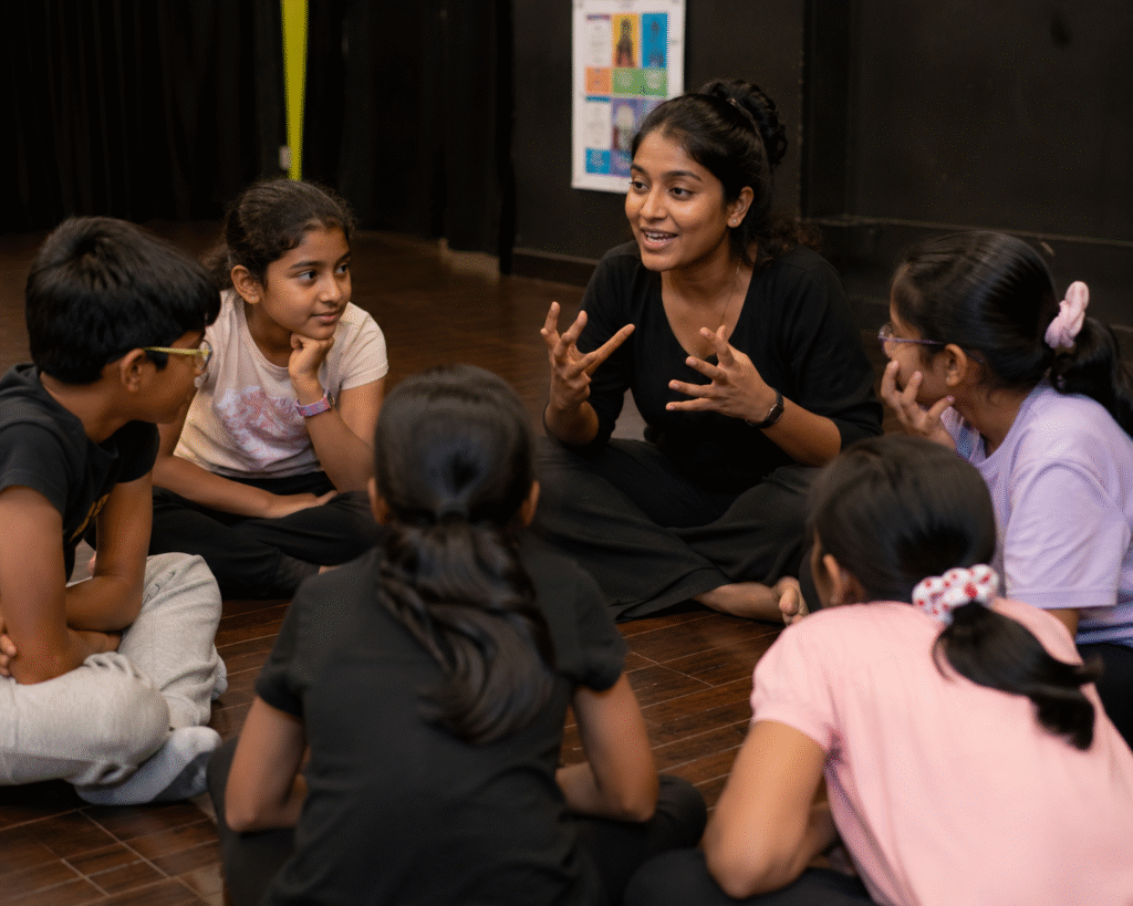  theatre mentor guiding children sitting in a discussion circle during an interactive acting workshop session  in jignasa nallagnadla.